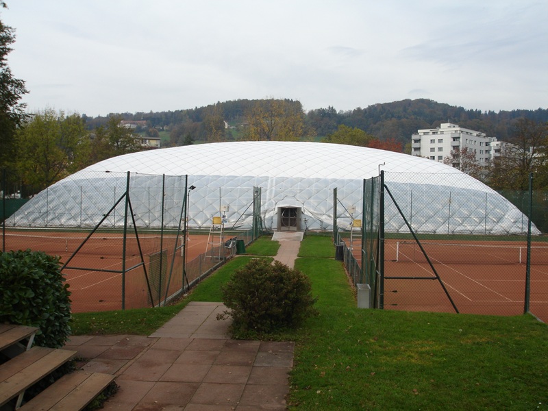 Tennishalle von aussen hinter Tennisplätzen